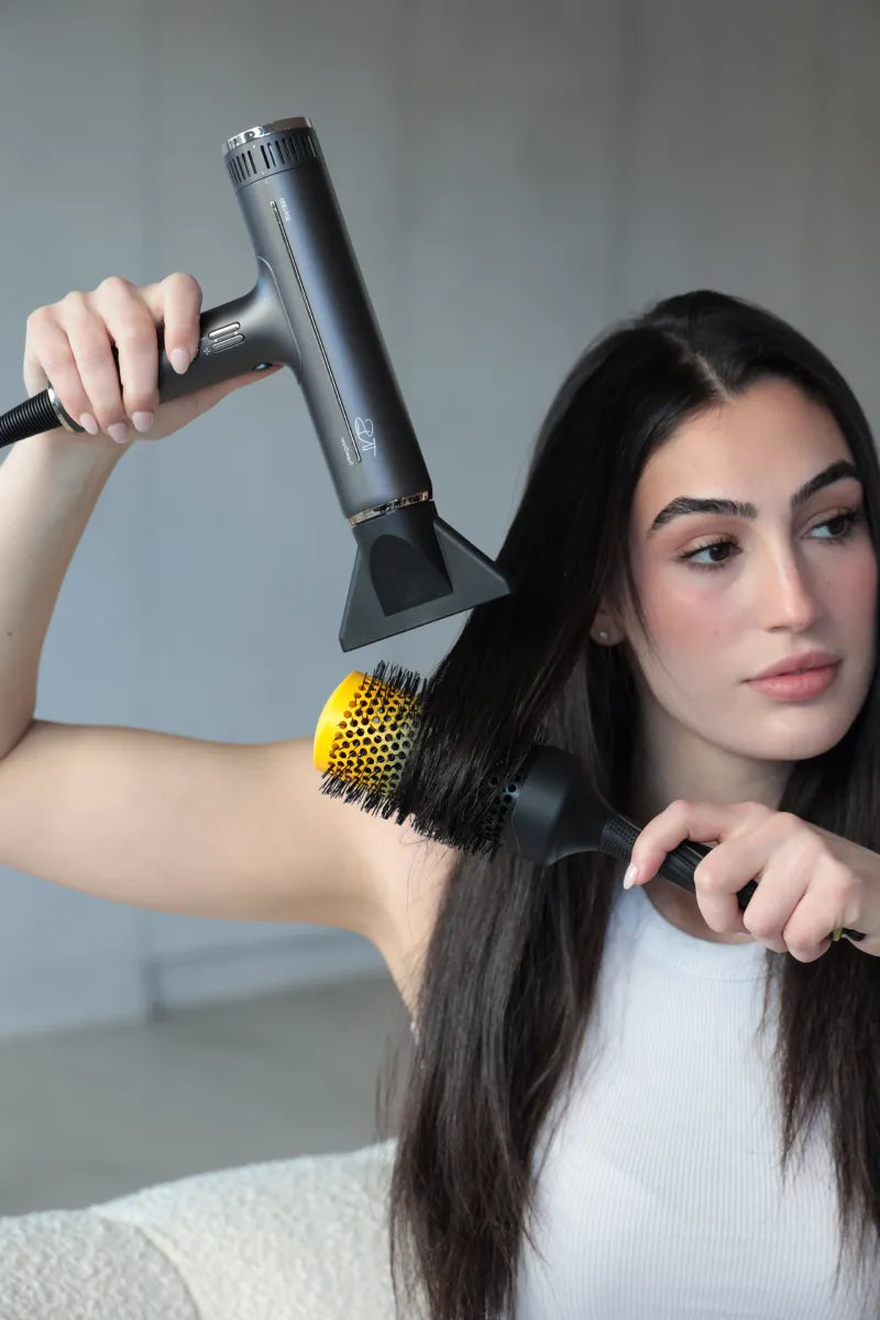 Blow drying hair with a dryer and round brush