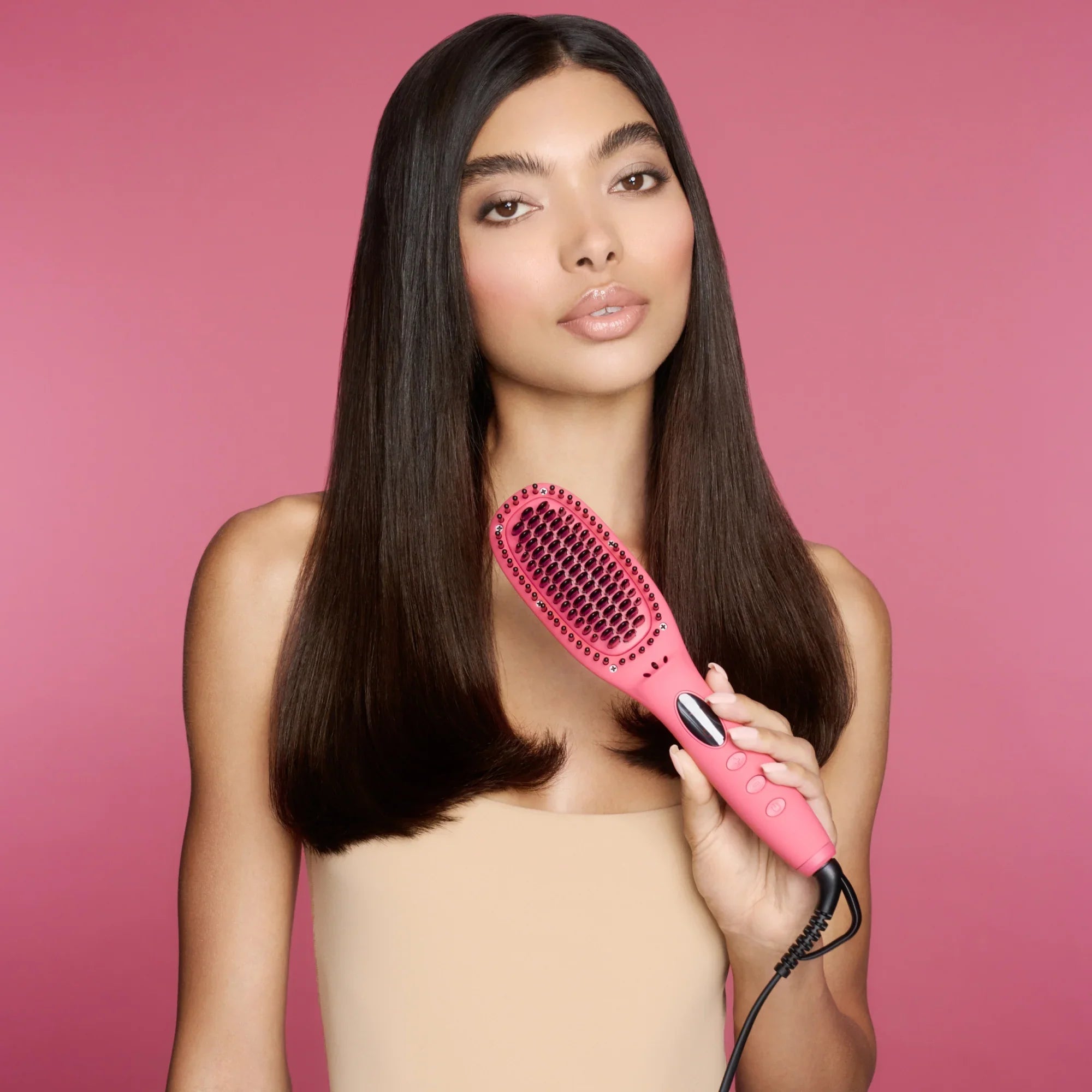 Model with sleek, straight hair holding the pink TNS Straightening Brush