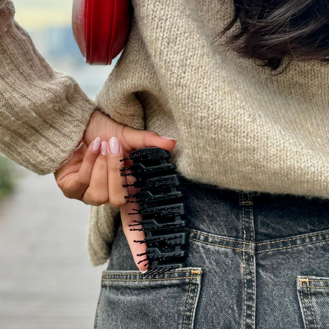 TNS flex-frame detangling brush tucked into a back jeans pocket