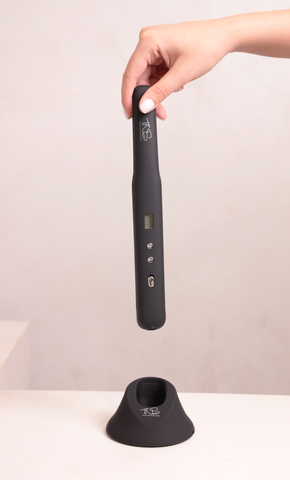 TNS cordless straightener lifted from its charging base